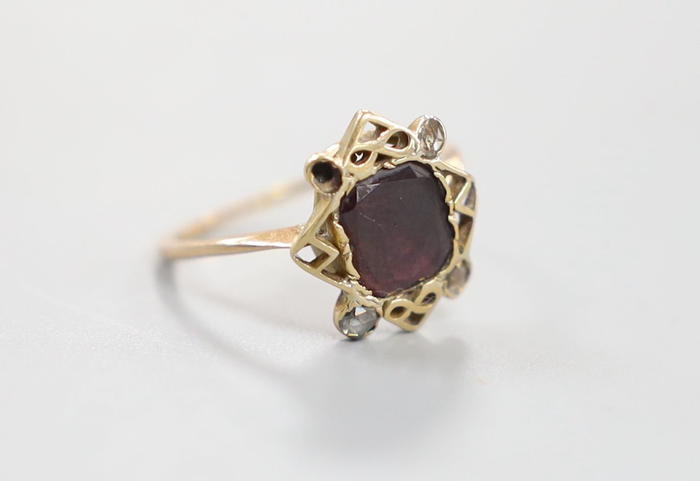 A 19th century yellow metal, garnet and four stone rose cut diamond set dress ring, size P/Q, gross 2.4 grams.